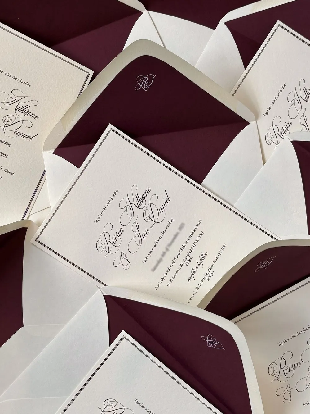 Burgundy-lined envelopes holding printed save the date cards